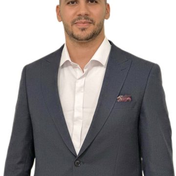 Abdel Bettahar puku päällä, katsoo kameraan.