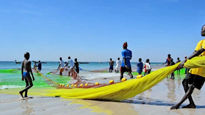 Senegalilaisia kalastajia rannalla verkon kanssa