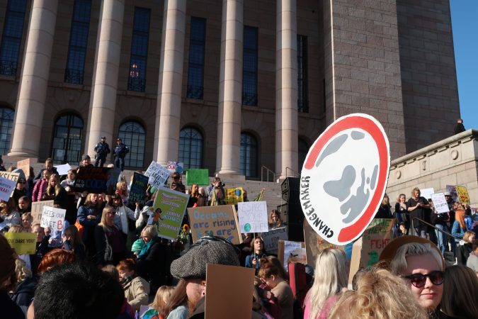 Ihmisiä eduskuntatalon edessä mielenosoituksessa