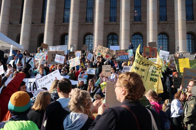 Ihmisiä eduskuntatalon edessä mielenosoituksessa