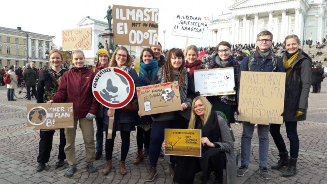 Vapaaehtoiset pitämässä kylttejä ilmastomarssilla