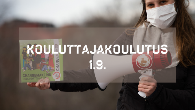 Iida pitää kädessään Changemakerin roolikorttiharjoitetta sekä megafonia. Etualalla teksti "kouluttajakoulutus"