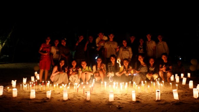 Ryhmäkuva Kambodzhan Changemakerin vapaaehtoisista kynttilänvalossa
