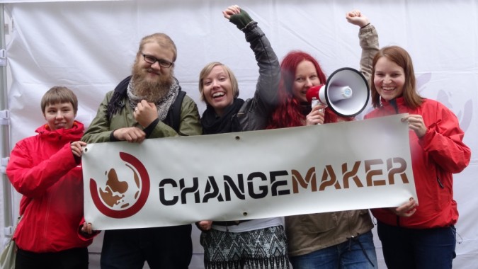 Vapaaehtoisia Changemaker-bannerin kanssa