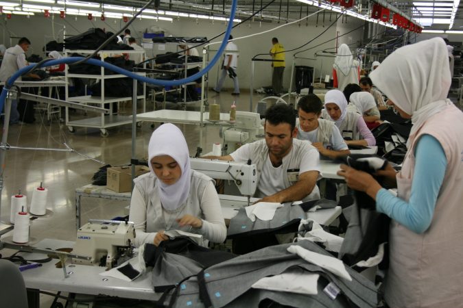 Työntekijöitä ompelemassa vaatetehtaalla